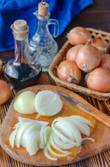 onion cut into half rings on a kitchen board