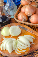onion cut into half rings on a kitchen board