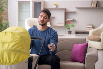 Young man looking after newborn at home