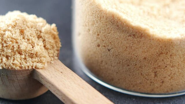 crystal brown sugar brown on a wooden spoon on table 