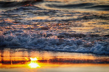 Piękny złocisty zachód słońca nad morzem i czerwona woda.