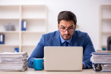 Young male employee and too much work in the office