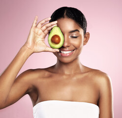 Obraz na płótnie Canvas Avocado, happy woman and healthy beauty in studio, pink background and aesthetic glow. African model, natural skincare and organic cosmetics for sustainability, vegan dermatology and facial nutrition
