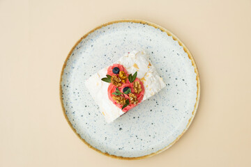 Meringue roll in round plate flat lay composition on beige background