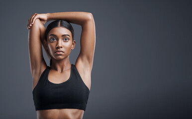 Fototapeta na wymiar Fitness, wellness and stretching with an athlete woman in studio on a gray background for mindset or health. Exercise, mission and warm up with an attractive young female model training on mockup