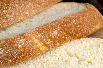 A cut loaf of round-shaped wheat bread