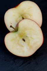 A ripe crispy apple cut into pieces on the table