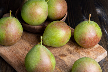 Whole ripe green pears on the board