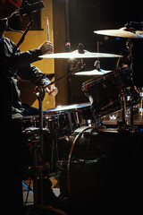 Fototapeta na wymiar Percussionist performing on rock drum set with drumsticks.