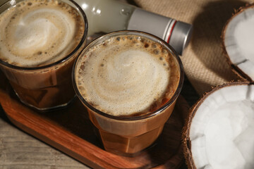 Glasses of tasty coffee with coconut syrup on wooden table, closeup