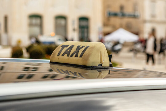Taxi sign on a cab in a city during daytime