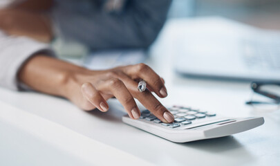 Calculator, accounting and woman hand working on finance investment report in office. Professional, taxes and closeup of female financial advisor doing calculation for asset management in workplace.