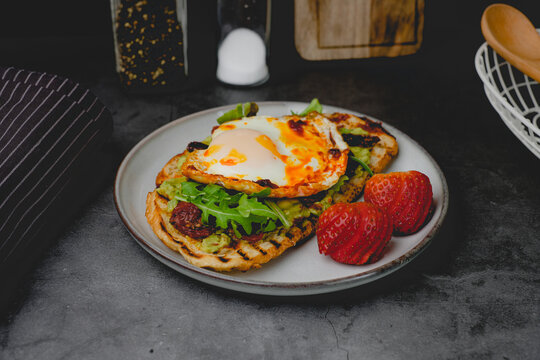 healthy breakfast and eating. Sourdough toast with avocado, arugula and fried eggs.