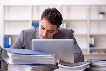 Fototapeta premium Young male employee working in the office