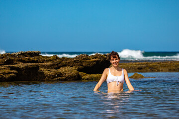 Happy girl in bikini enjoys a swim in rock pool, Flat Rock, Deepwater National Park, Agnes Water, Queensland, Australia