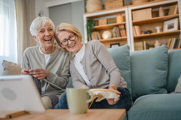 two women senior mature knitting and embroidery during leisure time