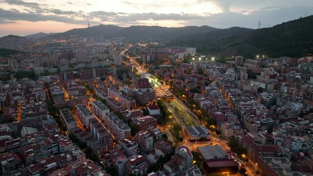 Barcelona at night, aerial view of Nou Barris and Sant Andreu districts. Streets with busy car traffic and city lights. Catalonia, Spain