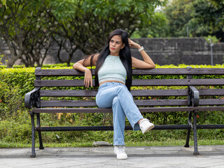girl with a long brunette hair in a bench in the park