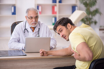 Obraz premium Young male patient visiting old male doctor