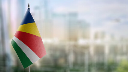 Small flags of the Seychelles on an abstract blurry background
