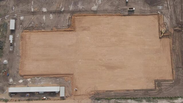 Aerial view overlooking a base for a construction site, near the Amazon river, in Parintins, Brazil - reverse, tilt, drone shot