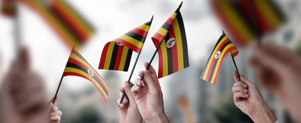 A group of people holding small flags of the Uganda in their hands