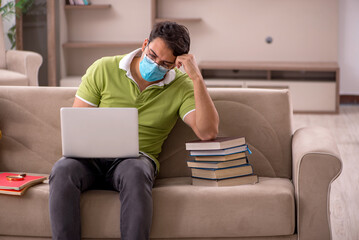 Young male student preparing for exams at home during pandemic