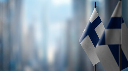 Fototapeta na wymiar Small flags of the Finland on an abstract blurry background