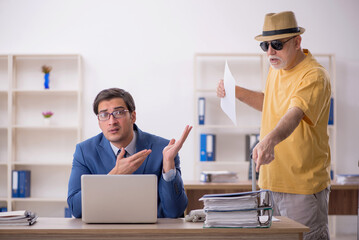 Old male boss and young male employee in summer vacation concept