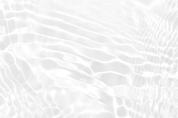White water with ripples on the surface. Defocus blurred transparent white colored clear calm water surface texture with splashes and bubbles. Water waves with shining pattern texture background.