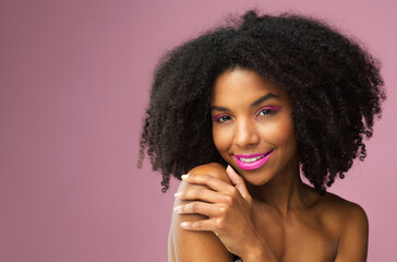 Hair care, face and smile of black woman with makeup in studio isolated on a pink background mockup for skincare. Hairstyle portrait, cosmetics and African female model with salon treatment for afro.