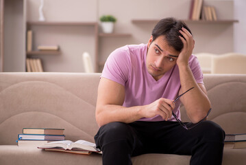Obraz premium Young male student preparing for exams at home