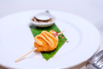 Deep-fried Prawn Balls topped with mayonnaise sauce The meatball skewers are placed on a plate. on the banquet table