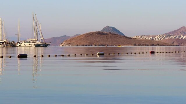 Beautiful bay with calm blue sea, sailboats, islands and mountains