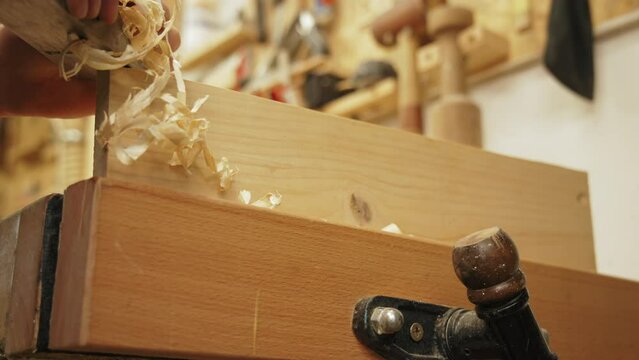 carpenter working in his workshop and using a jack plane for wood, closeup shot. High quality 4k footage