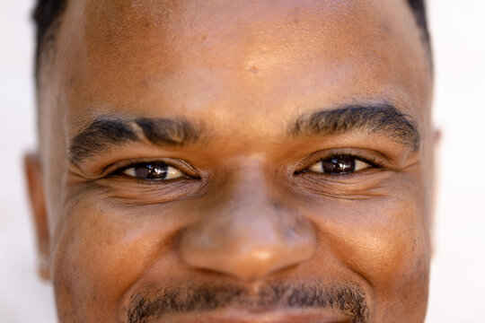 Closeup portrait of african american young man with black eyes smiling and posing confidently
