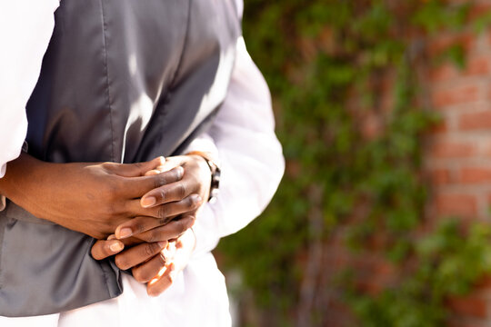 Cropped hands of african american young man embracing gay boyfriend at wedding ceremony