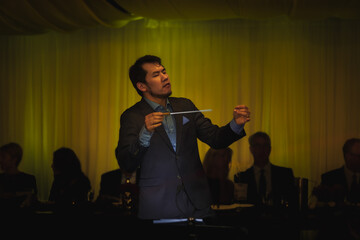 Male conductor conducting classical concert in informal setting