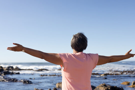 Senior african american woman with arms wide at seaside