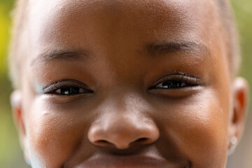 Portrait close up of eyes of smiling african american girl in garden