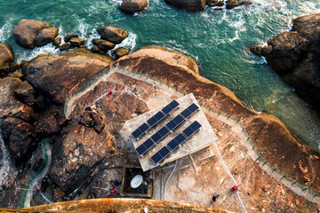 the aerial landscape image of sea and rocks with small solar plant