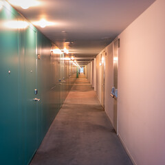 Long corridor of a modern hotel with multitude of room doors, Spain.