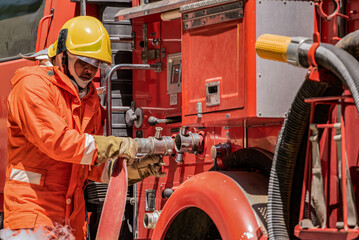 Firefighters are connecting fire hoses to fire trucks in order to help the victims.