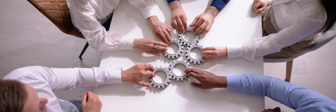 Diverse People Hands Holding Gear Wheels