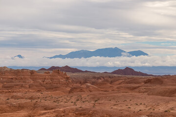 Panoramic view of the cloud covered Henry mountain range seen from the Goblin Valley State Park near Hanksville, Utah, USA. Unique Hoodoo Estrada sandstone rock formations in San Rafael Swell