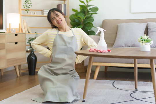 Maid feeling back pain and exhausted after cleaning in home and housework every day
