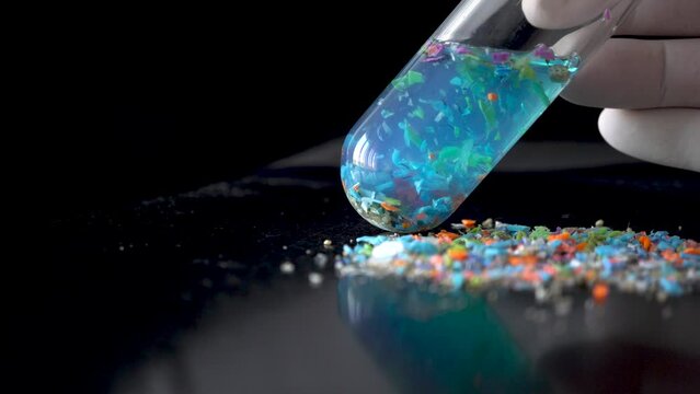 Close-up shot of a test tube full of micro plastics collected from the beach. Concept of water pollution and global warming. 