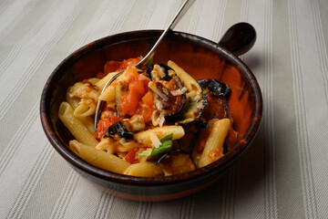 Pasta alla Norma or Penne Rigate with Eggplant and Tomato Sauce and Ricotta in a Rustic Terracotta Bowl