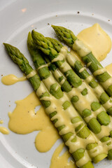 Green Asparagus with Sauce Hollandaise Served on a White Plate