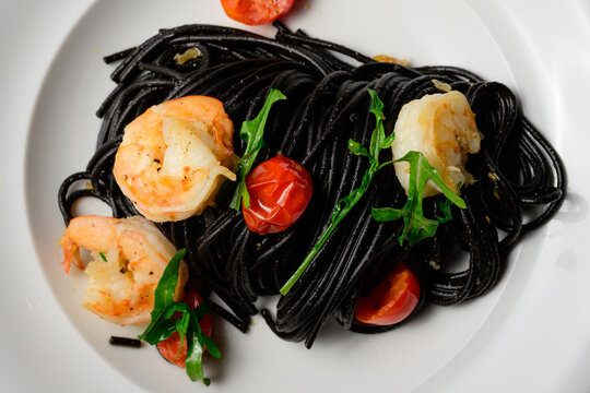 Spaghetti al Nero di Seppia con Gamberi, Italian Pasta with Squid Ink, Prawns, Tomato and Rucola